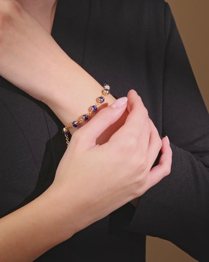Goldfarbenes Armband mit kleinen blauen Kristallperlen und filigranen Perlenkappen